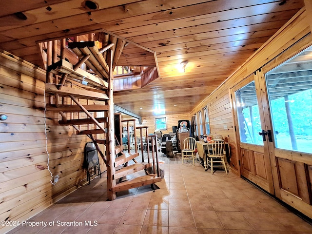 interior space featuring tile patterned floors, wooden walls, french doors, and wooden ceiling