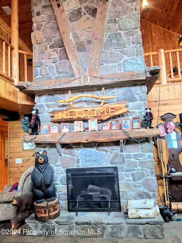 room details featuring wood walls, wooden ceiling, and a fireplace