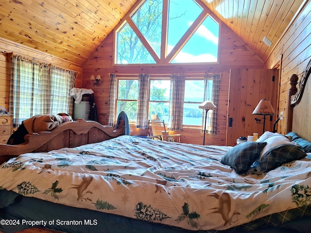 bedroom with high vaulted ceiling, wood ceiling, and wooden walls