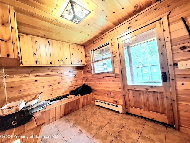 mudroom with light tile patterned floors, wooden ceiling, baseboard heating, and wooden walls