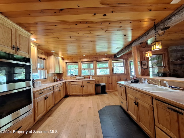 kitchen featuring sink, double oven, light hardwood / wood-style floors, pendant lighting, and wood ceiling