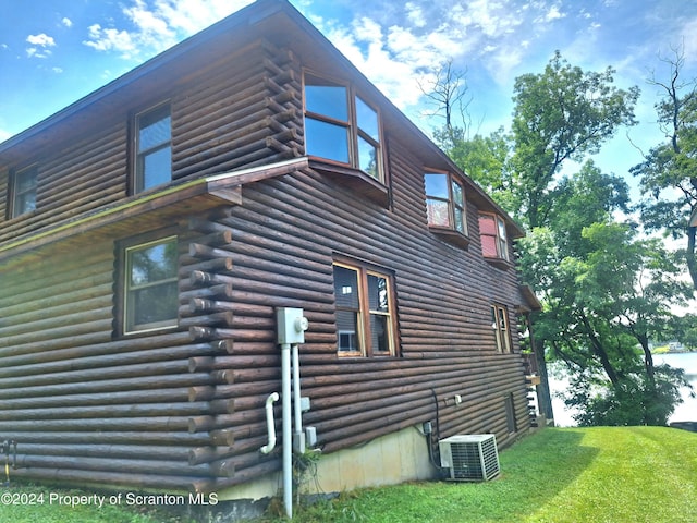 view of side of home featuring a yard and cooling unit