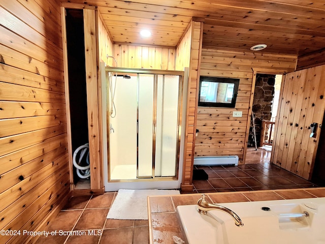 bathroom featuring wooden walls, tile patterned flooring, a washtub, baseboard heating, and wood ceiling