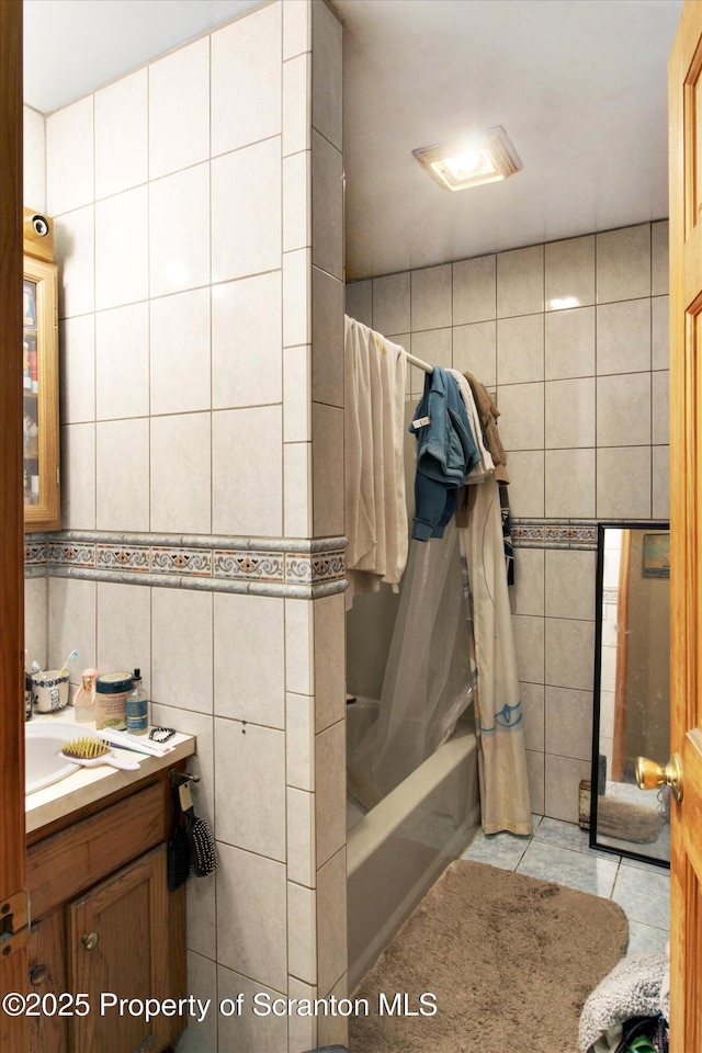 bathroom with shower / bath combo, tile walls, and vanity