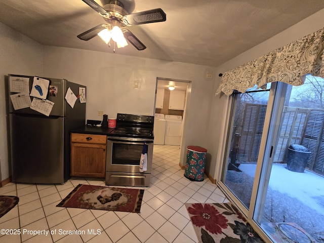 kitchen featuring appliances with stainless steel finishes, light tile patterned floors, ceiling fan, and washing machine and clothes dryer