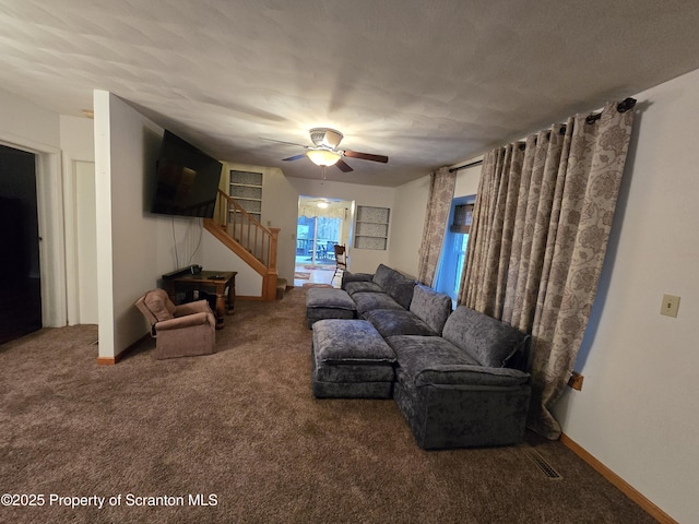 carpeted living room featuring ceiling fan and a textured ceiling