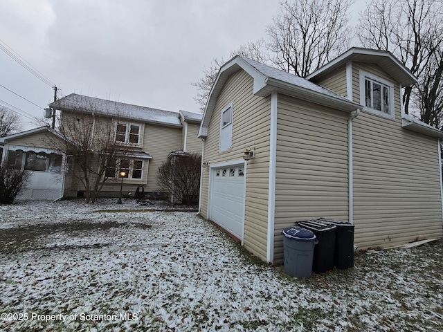 snow covered property with a garage