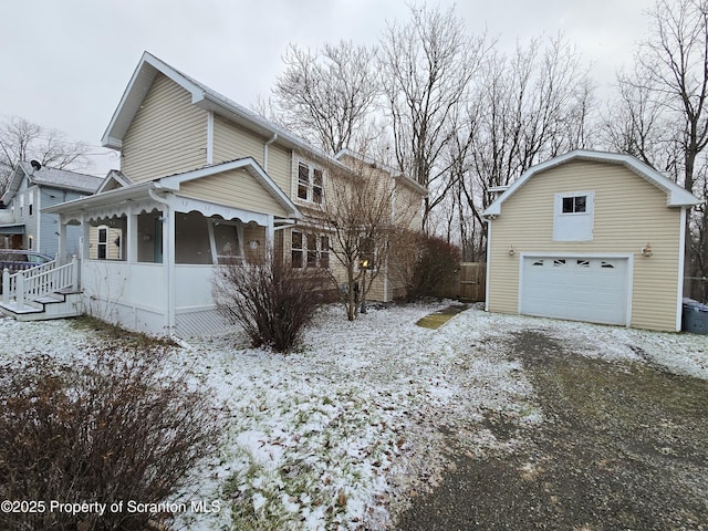 view of snow covered exterior featuring a porch and a garage