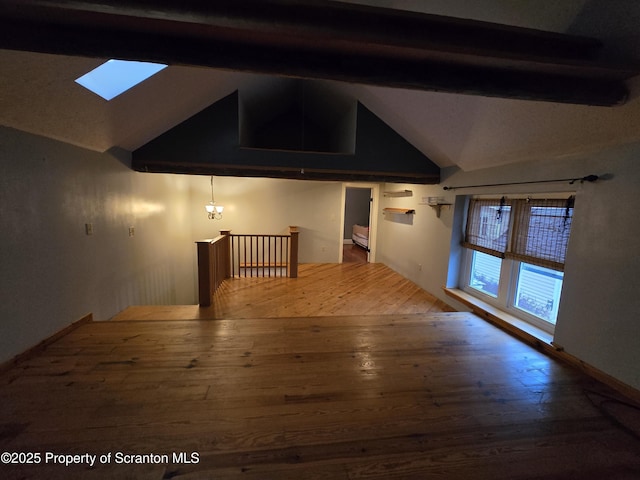 interior space with lofted ceiling with skylight and hardwood / wood-style flooring