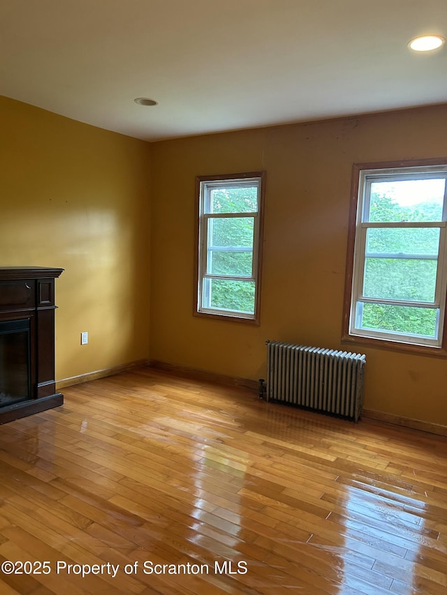 439 Old Union Rd, Equinunk, PA 18417 - unfurnished living room featuring radiator, plenty of natural light, a fireplace, light wood finished floors, and recessed lighting