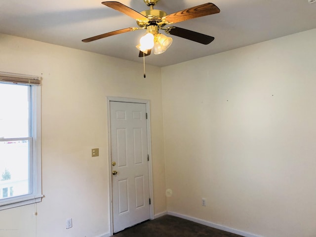 unfurnished room with dark carpet and baseboards