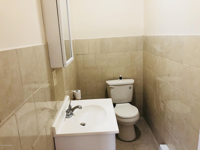 bathroom featuring toilet, tile patterned flooring, tile walls, and vanity