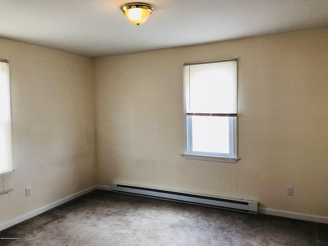 spare room featuring baseboards, dark carpet, and baseboard heating