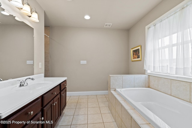 bathroom featuring tiled bath, tile patterned flooring, and vanity