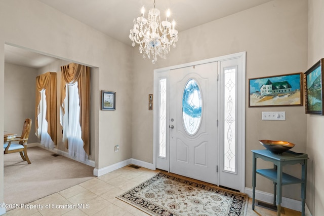 tiled entrance foyer featuring an inviting chandelier