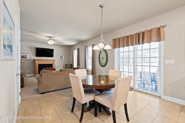 tiled dining area with ceiling fan with notable chandelier