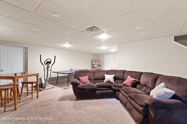 living room featuring carpet floors and a drop ceiling