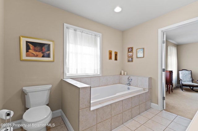 bathroom featuring toilet, tile patterned flooring, and a relaxing tiled tub