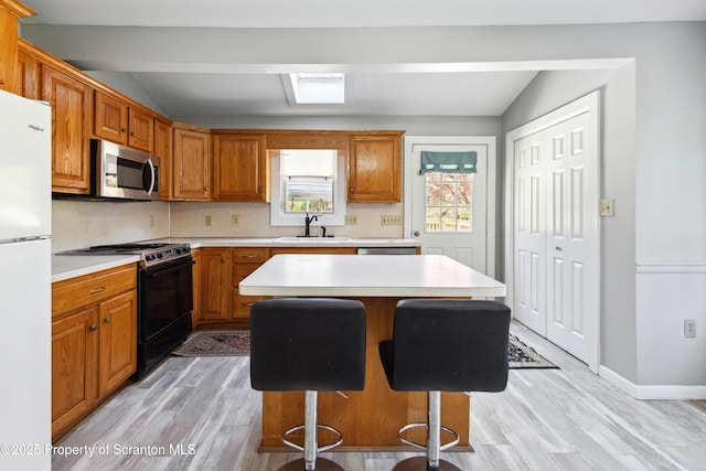 675 Apple Tree Rd, Harding, PA 18643 - kitchen with stainless steel microwave, black range with electric stovetop, freestanding refrigerator, light countertops, and light wood-style flooring
