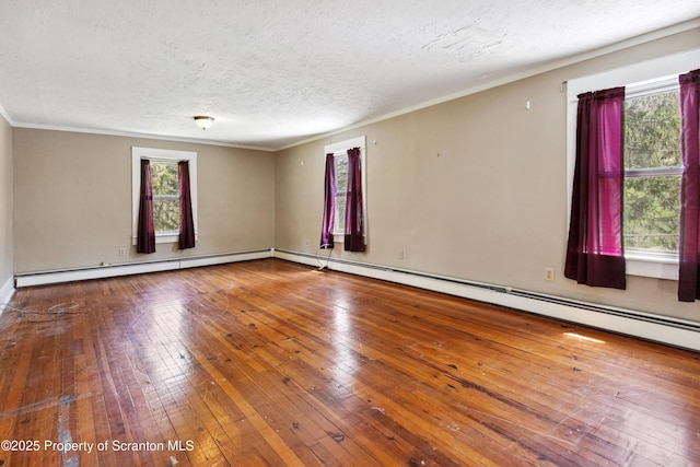 675 Apple Tree Rd, Harding, PA 18643 - empty room featuring plenty of natural light, a textured ceiling, hardwood / wood-style flooring, crown molding, and a baseboard heating unit