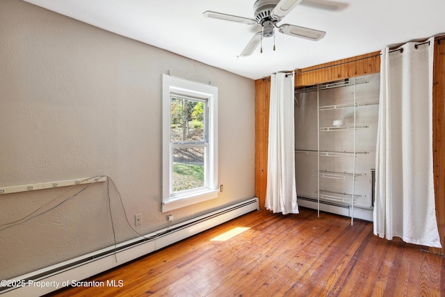 675 Apple Tree Rd, Harding, PA 18643 - unfurnished bedroom with a baseboard radiator, hardwood / wood-style floors, a textured wall, and ceiling fan