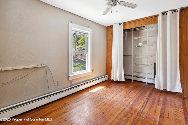 675 Apple Tree Rd, Harding, PA 18643 - unfurnished bedroom featuring a baseboard radiator, hardwood / wood-style flooring, a textured wall, and a ceiling fan