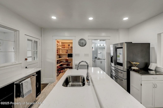 kitchen featuring recessed lighting, white cabinets, a sink, and stainless steel fridge with ice dispenser