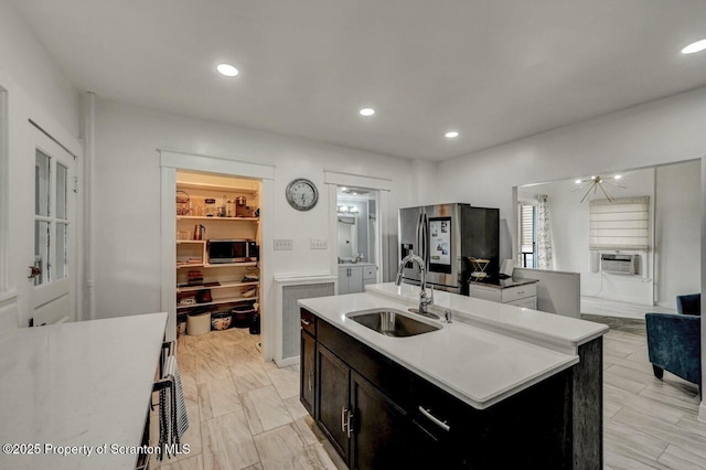 kitchen with appliances with stainless steel finishes, recessed lighting, a kitchen island with sink, and a sink