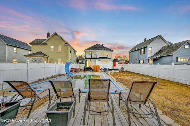 wooden terrace with outdoor dining space and a fenced backyard