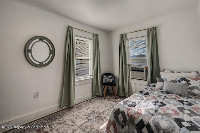 bedroom with multiple windows, baseboards, and cooling unit