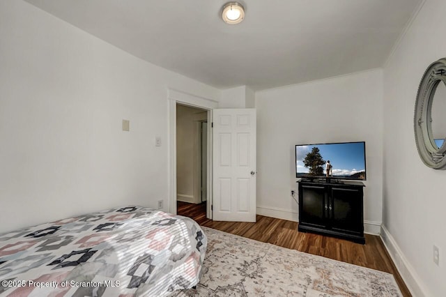 bedroom featuring dark wood finished floors and baseboards