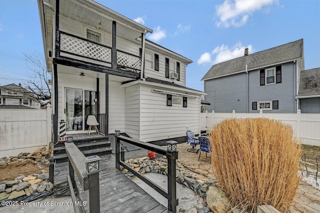 back of property featuring fence and a balcony