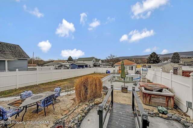 back of property featuring a fenced backyard, a residential view, and a patio