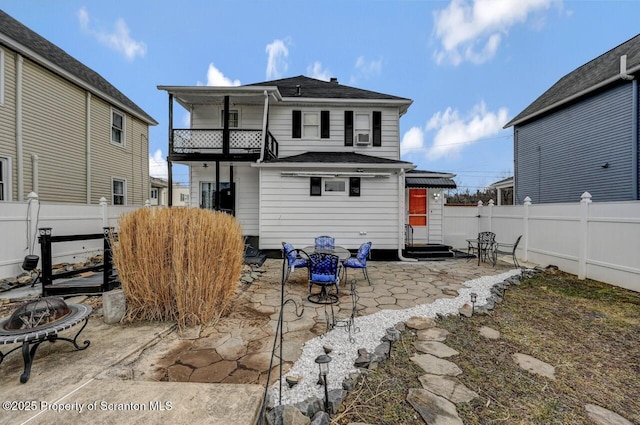 back of property featuring entry steps, a patio area, a fenced backyard, and a balcony