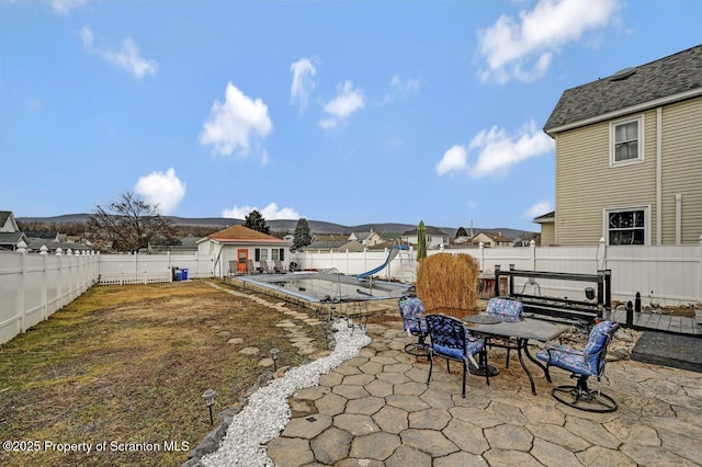 view of yard with a patio area, a fenced backyard, outdoor dining area, and an outdoor structure