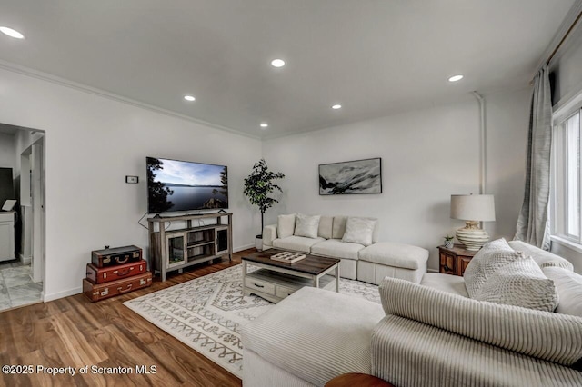 living room featuring ornamental molding, recessed lighting, baseboards, and wood finished floors