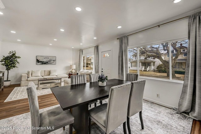 dining area featuring baseboards, wood finished floors, and recessed lighting