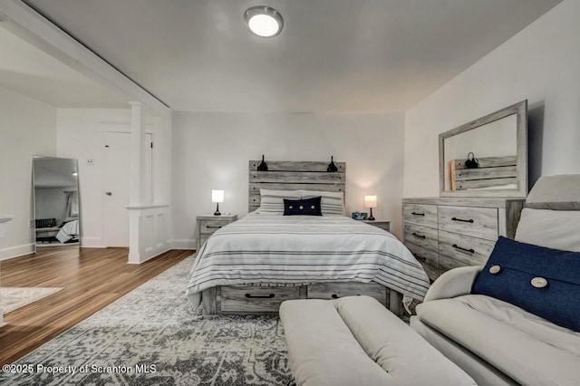 bedroom with baseboards and wood finished floors