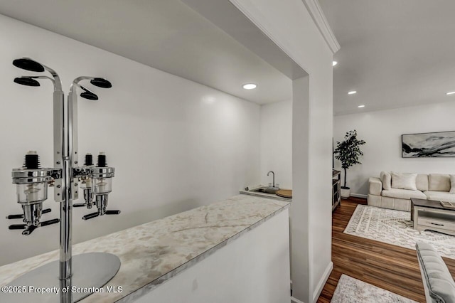 bar featuring recessed lighting, dark wood-style flooring, indoor wet bar, and a sink