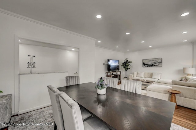 dining space with ornamental molding, wood finished floors, and recessed lighting