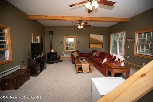 living room with ceiling fan, a baseboard heating unit, beamed ceiling, carpet floors, and a wood stove