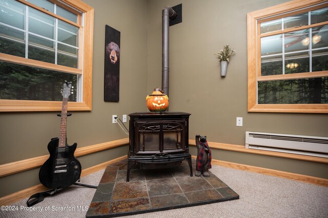 interior details with a wood stove and a baseboard radiator