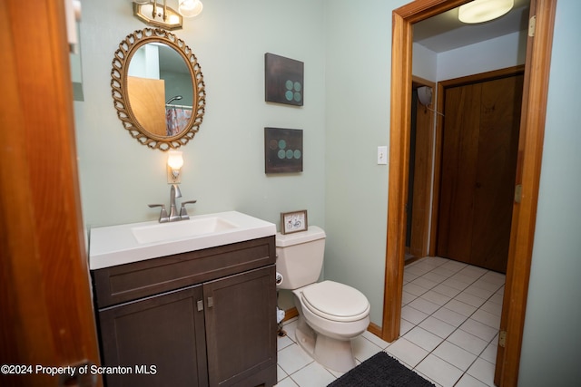 bathroom featuring tile patterned flooring, vanity, and toilet