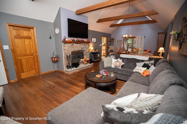 living room with hardwood / wood-style flooring, lofted ceiling with beams, a fireplace, and a chandelier