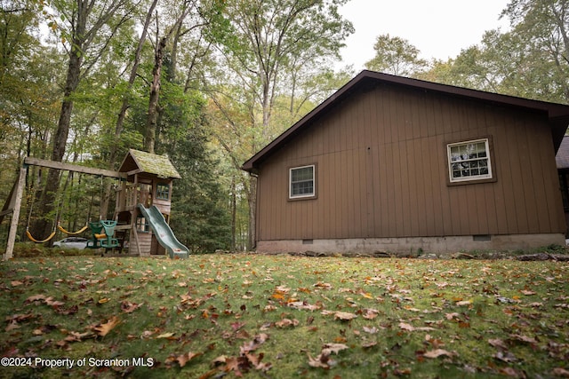 view of property exterior with a playground and a lawn