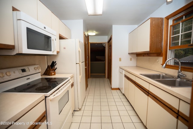 kitchen with sink, white cabinets, white appliances, and light tile patterned floors