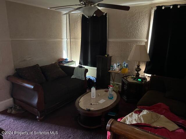 carpeted living room with ceiling fan