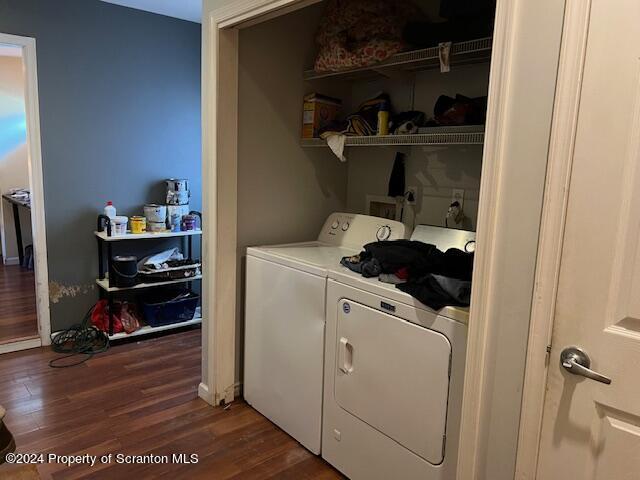 clothes washing area featuring washer and clothes dryer and dark wood-type flooring