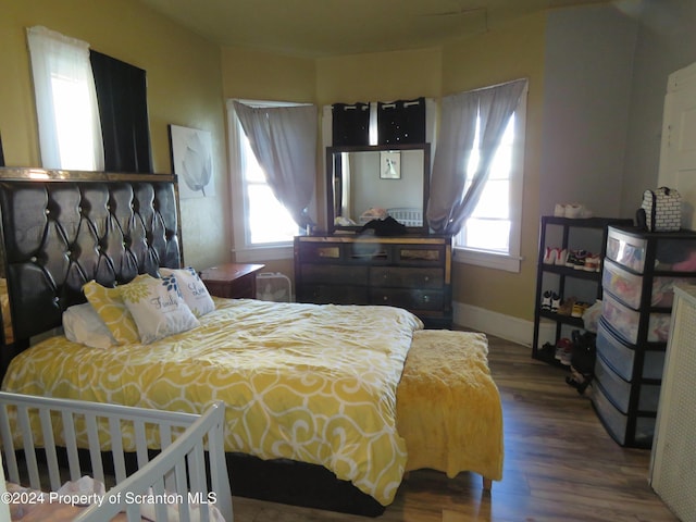 bedroom with hardwood / wood-style flooring and multiple windows