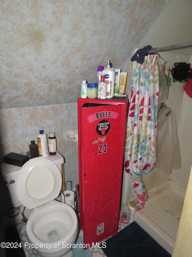 bathroom featuring curtained shower, toilet, and vaulted ceiling